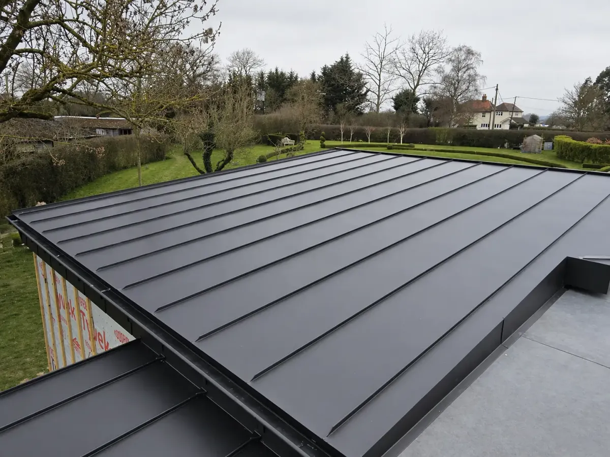 Dark zinc standing seam roof on a low-pitched residential extension